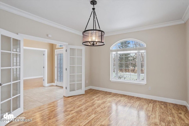 unfurnished dining area featuring a chandelier, french doors, light hardwood / wood-style flooring, and crown molding