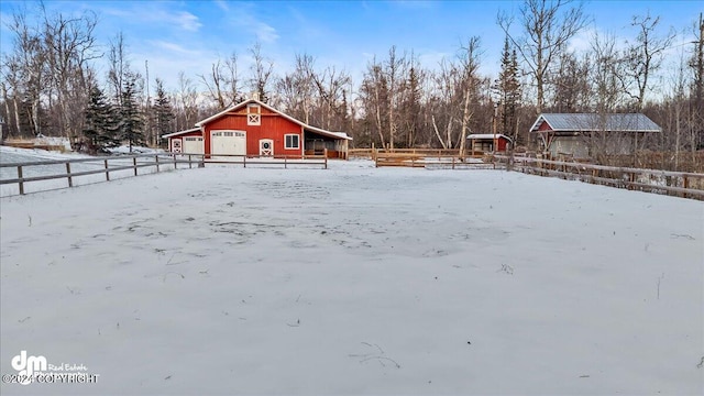 yard layered in snow featuring an outdoor structure and a garage