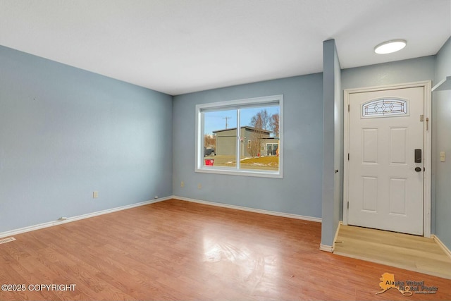 foyer entrance with visible vents, baseboards, and light wood finished floors