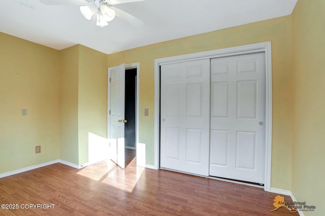 unfurnished bedroom featuring a closet, a ceiling fan, baseboards, and wood finished floors