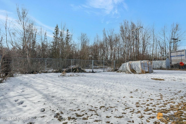 yard covered in snow with fence