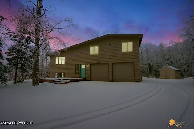 view of property with a garage and a storage shed