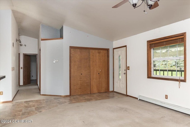 interior space with lofted ceiling, ceiling fan, and a baseboard heating unit