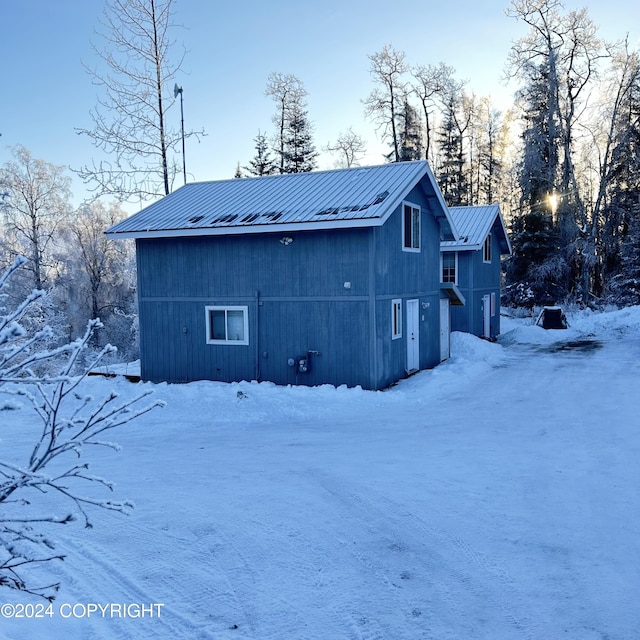 view of snow covered back of property