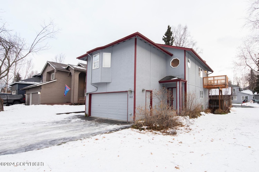 snow covered house with a garage