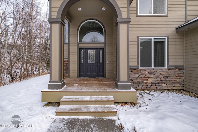 snow covered property entrance featuring covered porch