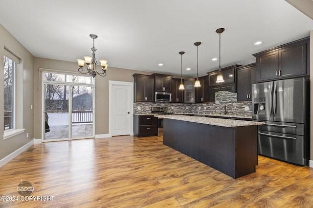 kitchen with hanging light fixtures, a center island, stainless steel appliances, and dark brown cabinets