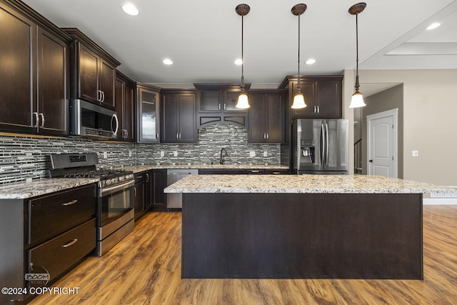 kitchen featuring sink, a center island, hanging light fixtures, and appliances with stainless steel finishes