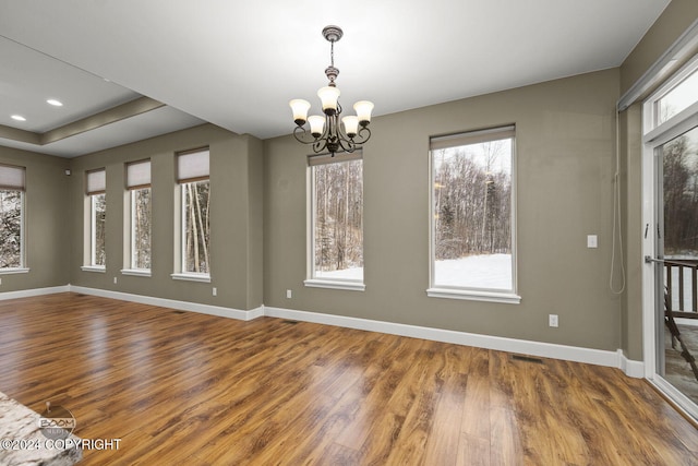 unfurnished dining area featuring hardwood / wood-style floors and a notable chandelier