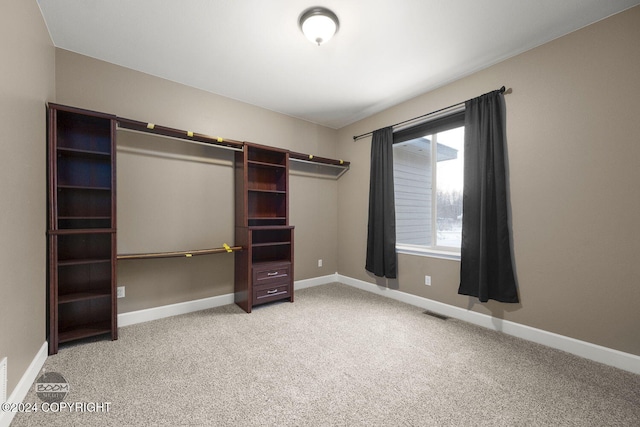 walk in closet featuring light carpet