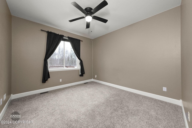 carpeted spare room with ceiling fan