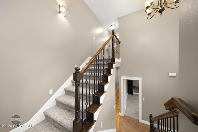 stairs featuring a notable chandelier