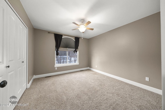 unfurnished bedroom with carpet, ceiling fan, and a closet