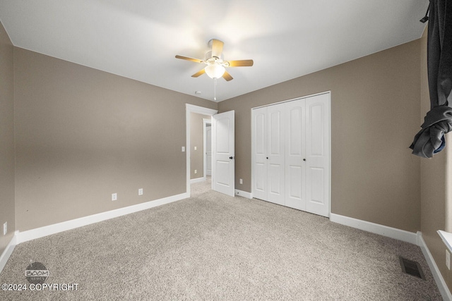 unfurnished bedroom with carpet flooring, ceiling fan, and a closet