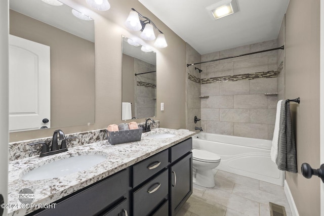 full bathroom featuring tile patterned flooring, toilet, vanity, and tiled shower / bath