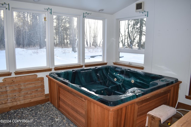 interior space featuring a bathtub and vaulted ceiling