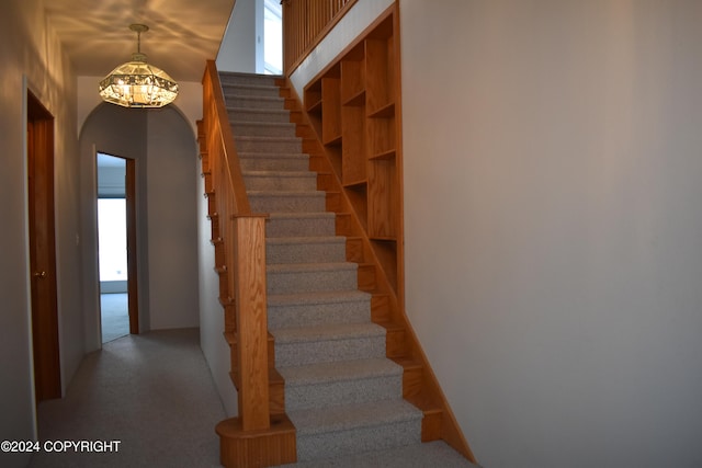 stairway featuring an inviting chandelier