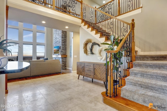 stairs featuring a towering ceiling and baseboards