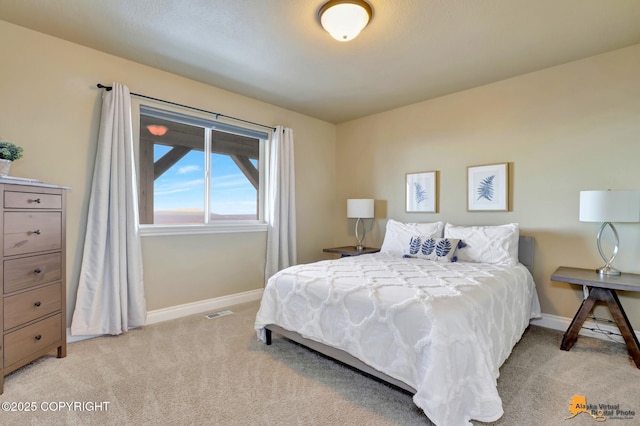 bedroom featuring light carpet, visible vents, and baseboards