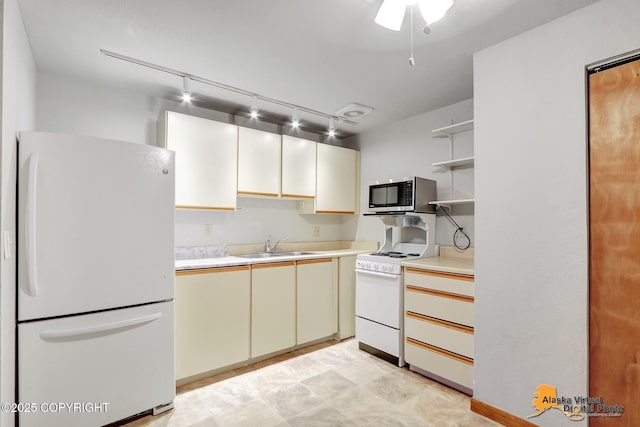 kitchen with sink, white appliances, and rail lighting