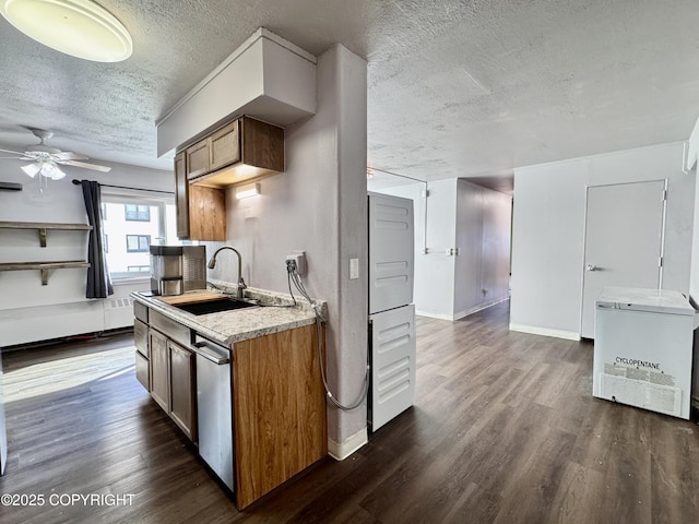 kitchen with dark wood finished floors, a textured ceiling, light countertops, and a sink