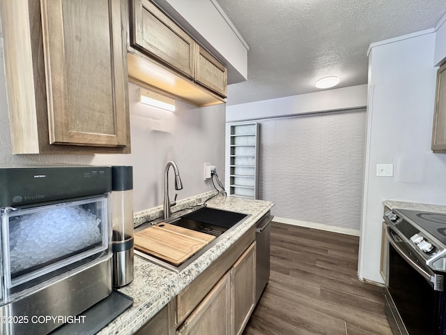 kitchen with baseboards, dark wood-style flooring, a sink, appliances with stainless steel finishes, and a textured ceiling