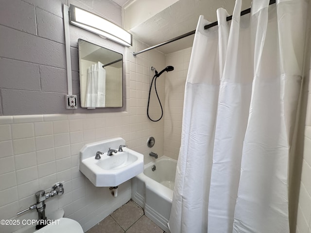 full bathroom with toilet, a sink, tile walls, shower / bath combination with curtain, and tile patterned flooring