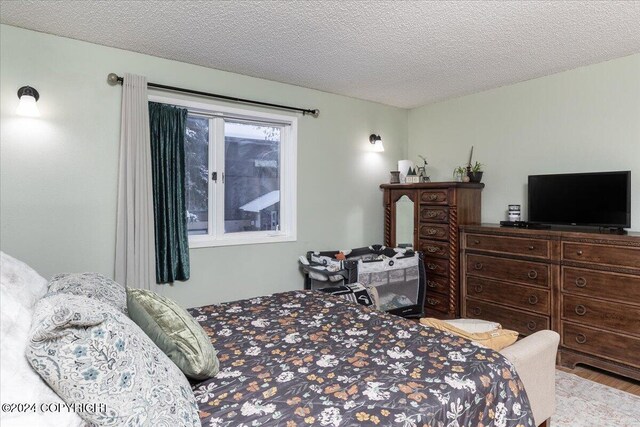 bedroom featuring wood-type flooring and a textured ceiling