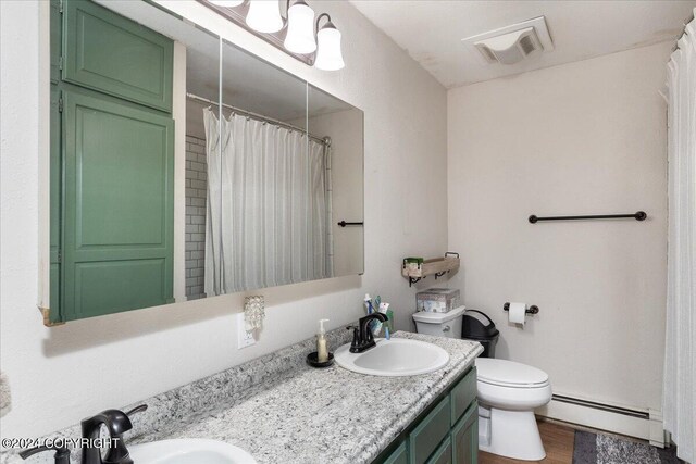 bathroom with a baseboard radiator, a shower with curtain, hardwood / wood-style floors, toilet, and vanity