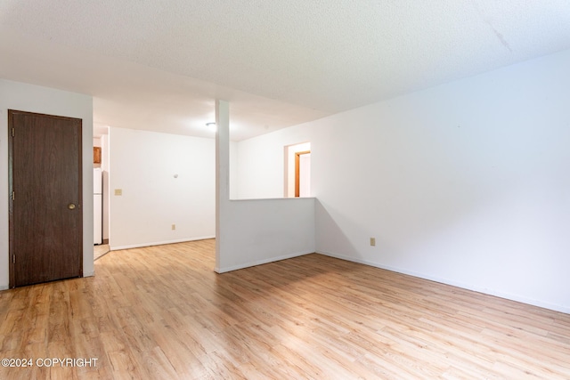 empty room featuring light hardwood / wood-style floors and a textured ceiling