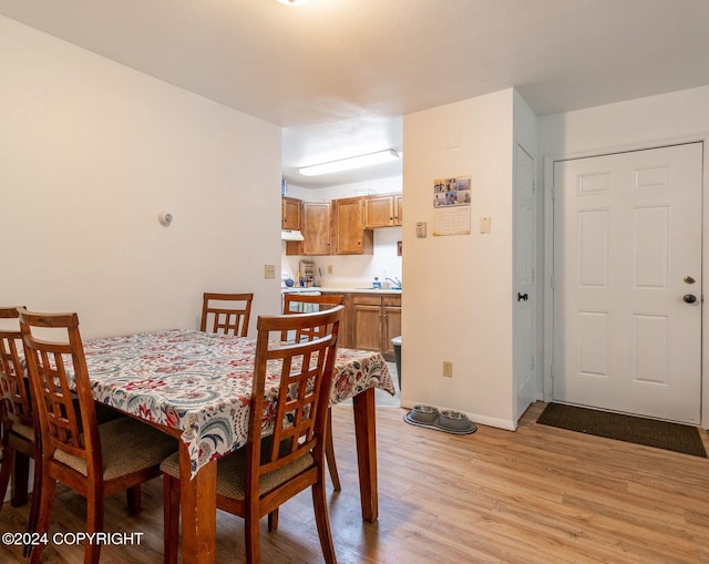 dining area with light hardwood / wood-style floors and sink