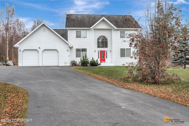 view of front property featuring a garage and a front lawn