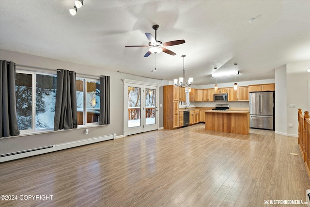 unfurnished living room featuring ceiling fan with notable chandelier, light hardwood / wood-style floors, a textured ceiling, and a baseboard radiator