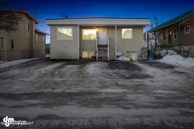 rear view of house with entry steps and fence