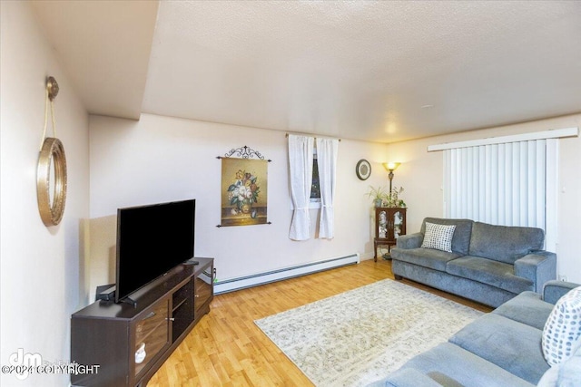 living room with a baseboard radiator, light hardwood / wood-style flooring, and a textured ceiling