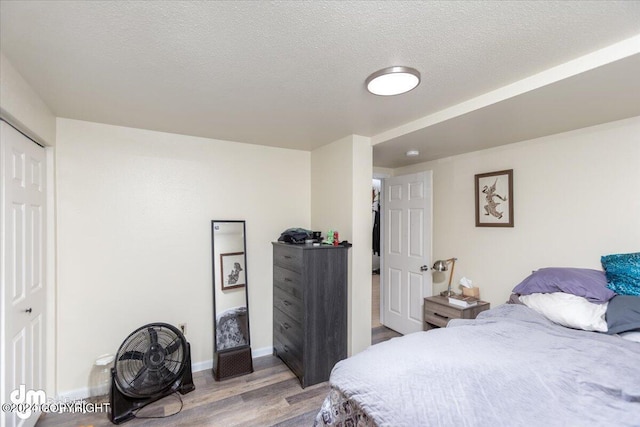 bedroom featuring a closet, a textured ceiling, and light wood-type flooring