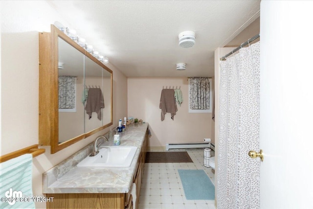 bathroom featuring vanity, a baseboard heating unit, and a textured ceiling