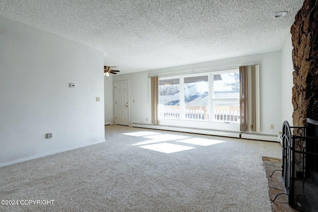 unfurnished living room with carpet flooring, a textured ceiling, a stone fireplace, and a baseboard heating unit