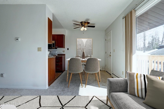 dining area with ceiling fan, light colored carpet, baseboard heating, and a textured ceiling