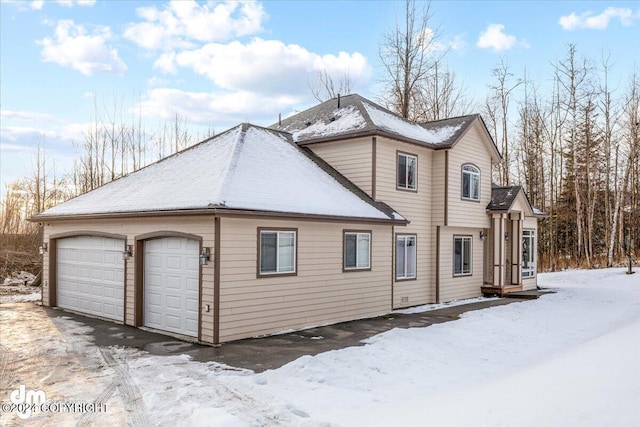 view of snow covered exterior featuring a garage