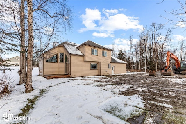 view of snow covered back of property