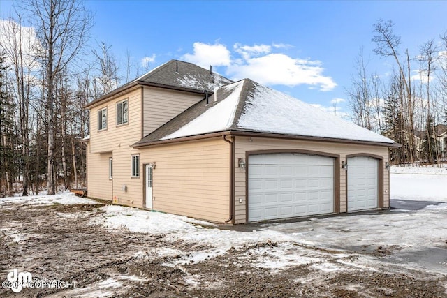 view of snow covered exterior featuring a garage