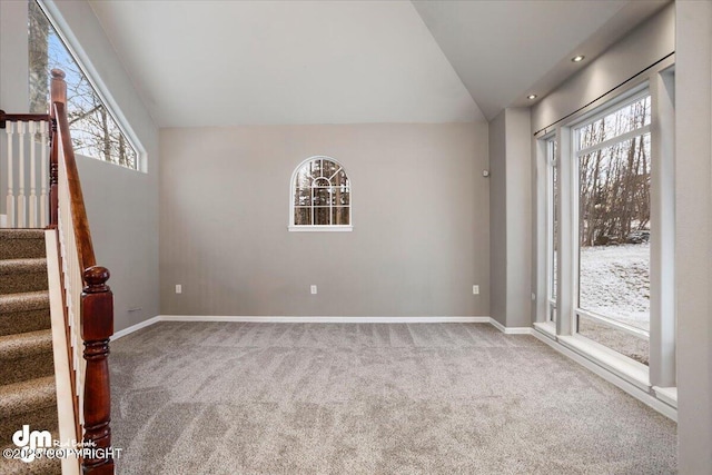 interior space featuring lofted ceiling, a wealth of natural light, and carpet