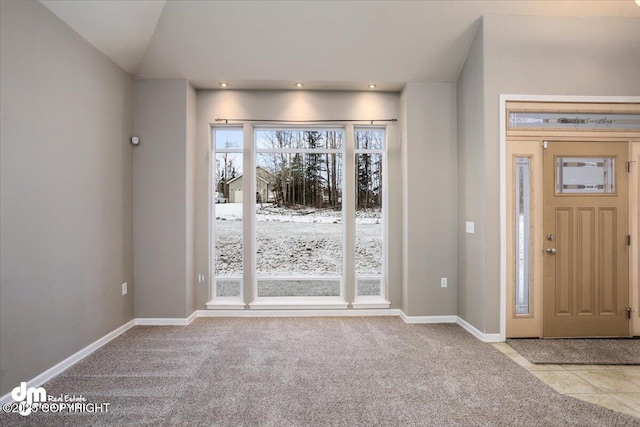 entryway with light carpet and vaulted ceiling