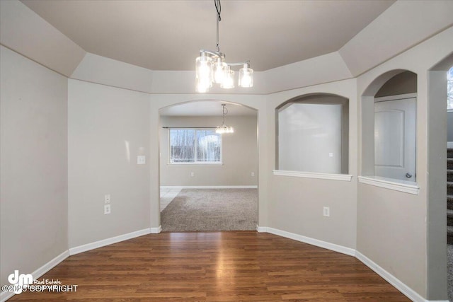 unfurnished dining area with an inviting chandelier and dark wood-type flooring