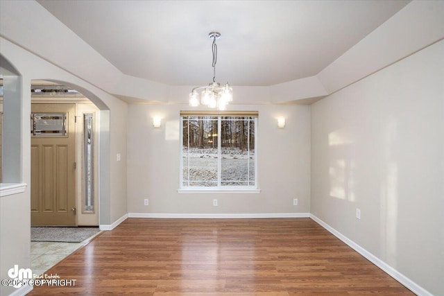 unfurnished dining area with hardwood / wood-style flooring and an inviting chandelier