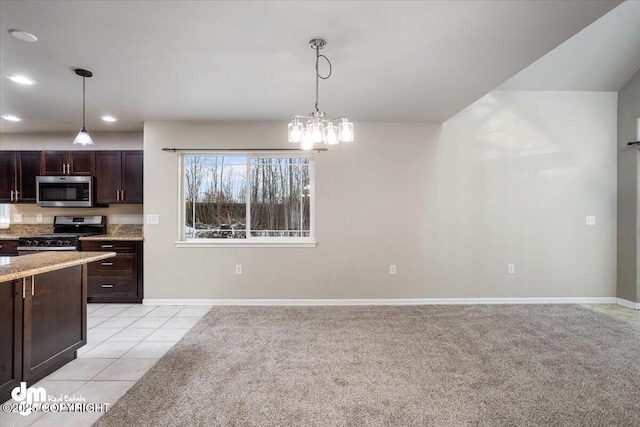 kitchen with light tile patterned floors, an inviting chandelier, hanging light fixtures, stainless steel appliances, and dark brown cabinetry