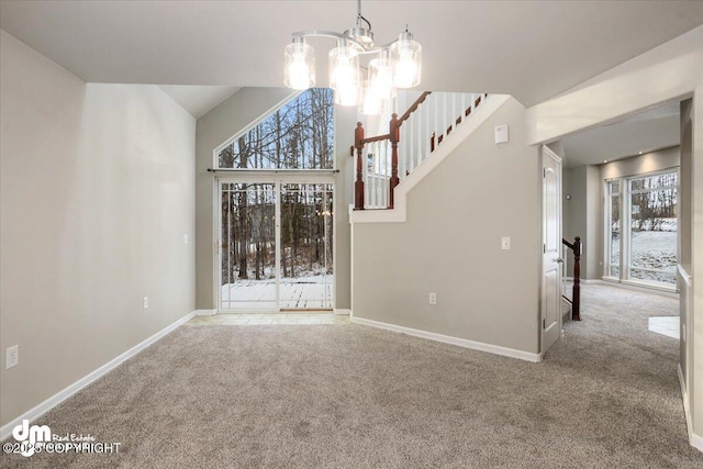 unfurnished living room featuring a healthy amount of sunlight, carpet, and a notable chandelier