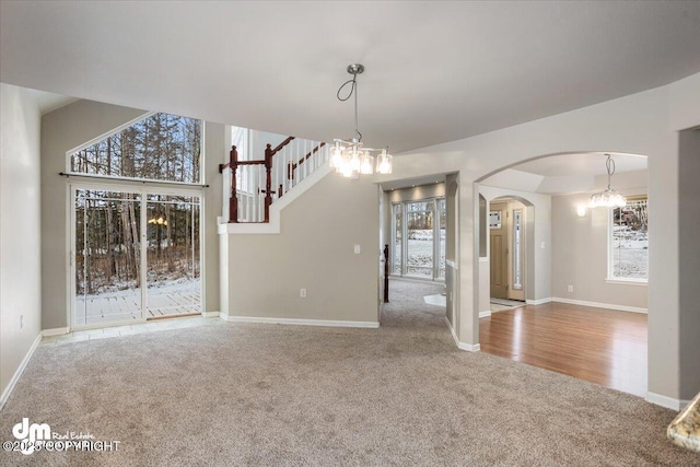 interior space featuring light carpet and a notable chandelier