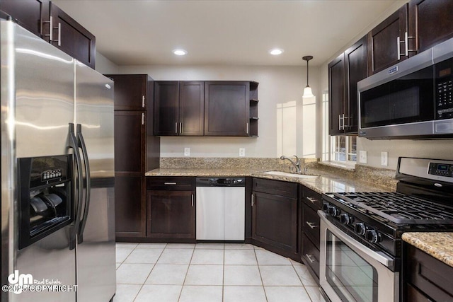 kitchen featuring dark brown cabinetry, stainless steel appliances, decorative light fixtures, and sink